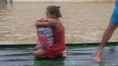 inspiringlife.pt - Menina a salvar os seus livros durante enchente torna-se viral nas redes sociais