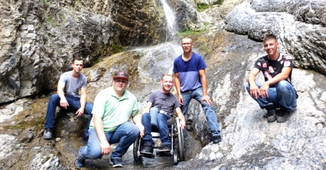 Eles carregaram o seu amigo numa cadeira de rodas até a uma cascata